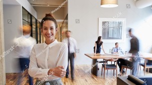 stock-photo-portrait-of-young-white-woman-in-a-busy-modern-workplace-796346011.jpg